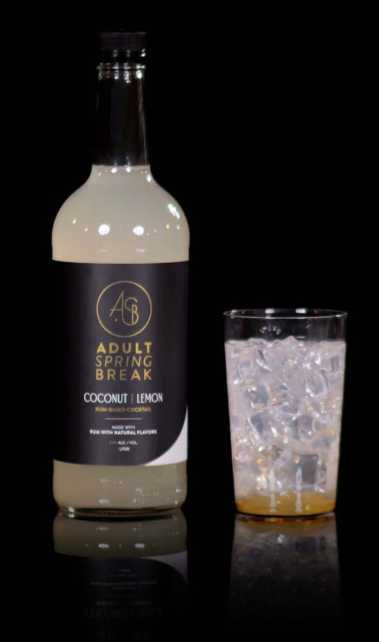 Coconut lemon cocktail bottle next to glass